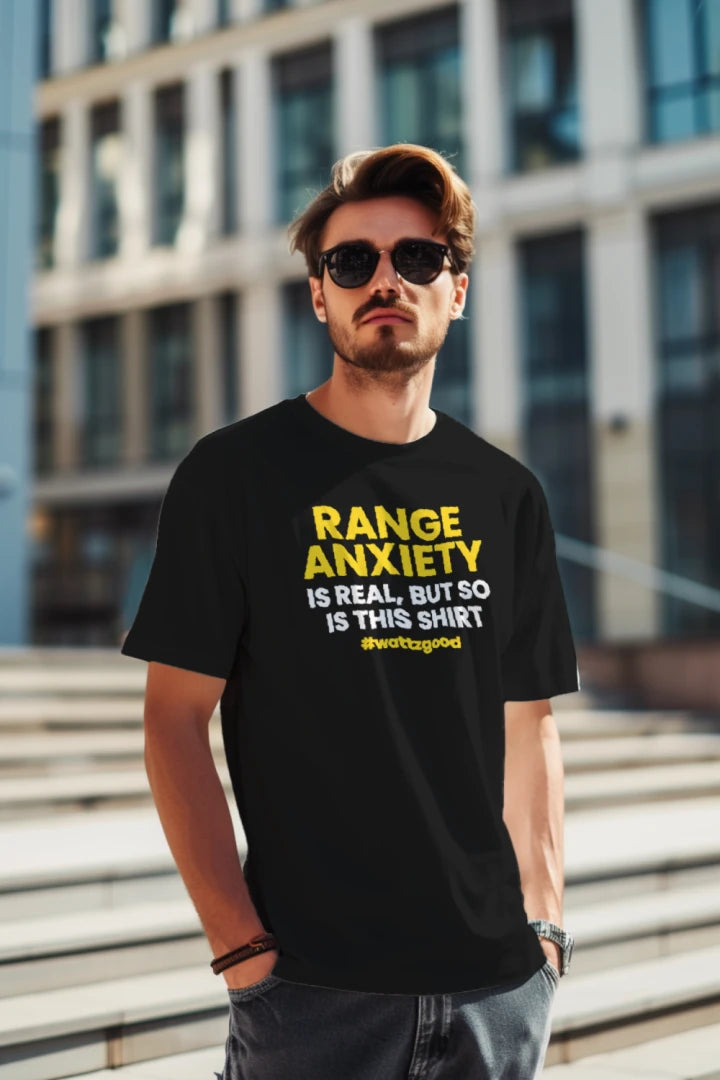 Man in the city wearing the black Wattz Good "Range Anxiety Is Real, But So Is This Shirt" EV graphic tee