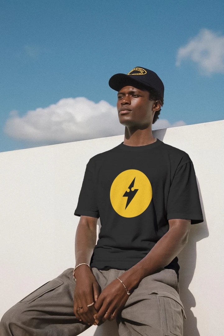 Man wearing the black Wattz Good logo tee with a large yellow lightning bolt circle
